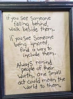 an embroidered poem in a frame with writing on the bottom and words above it that read if you see someone falling behind, walk beside them