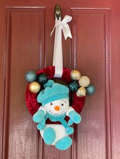 a snowman wreath hanging on the front door