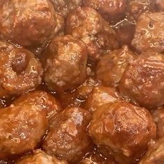 some meatballs are being cooked in sauce