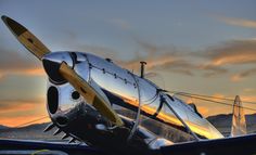 an airplane is parked on the tarmac at sunset