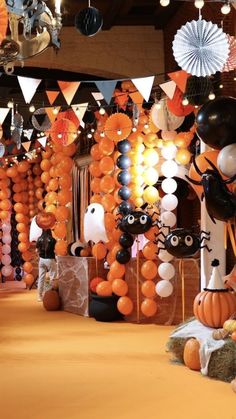 an assortment of halloween decorations on display in a room filled with orange and black balloons