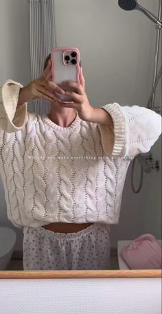 a woman taking a selfie in the mirror with her cell phone while wearing pajamas