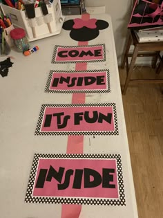 some pink and black signs on a table