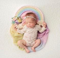 a baby is sleeping on a rainbow colored blanket