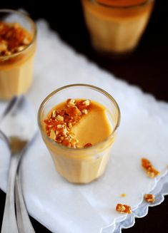 two desserts are sitting on a napkin with spoons