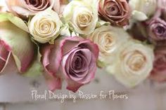 a bouquet of pink and white roses sitting on top of a tile floor next to a wall