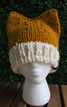 a knitted cat hat sitting on top of a white mannequin's head