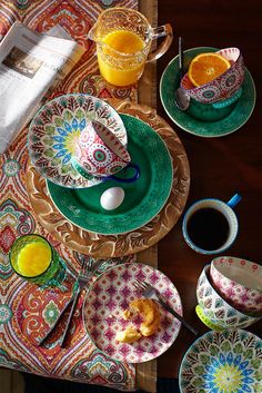 the table is set with plates, cups and utensils