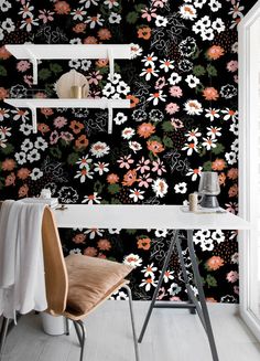 the wallpaper in this room is black and has flowers on it, as well as shelves