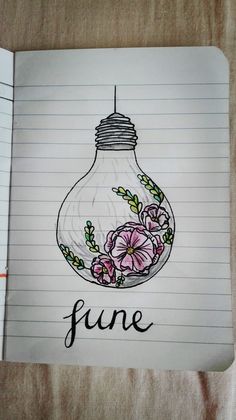 an open notebook with a drawing of a light bulb filled with flowers and the word june written in cursive writing