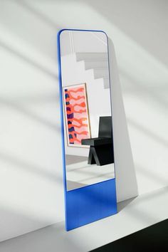 a blue and white mirror sitting on top of a table next to a black chair