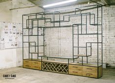 an empty room with shelves and drawers in the center, next to a white brick wall