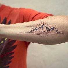 a man with a mountain tattoo on his arm