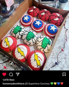 some cupcakes are in a box with captain america icing on them and decorated like superheros