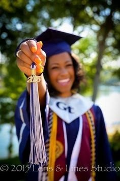 a woman in graduation cap and gown holding up an orange tassel with the letter c on it