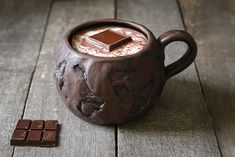 there is a chocolate mug and some pieces of chocolate on the table