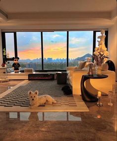 a living room filled with furniture and a dog laying on the floor in front of large windows