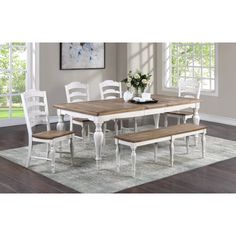 a dining room table with white chairs and a bench