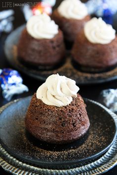 chocolate cupcakes with white frosting on black plates