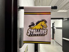 a college flag hanging from the side of a locker door in a hallway next to some locker doors