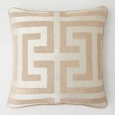 a beige and white pillow on a white wall