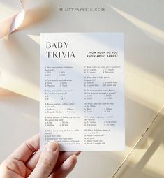 a person holding up a baby trivia card