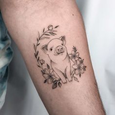 a small pig tattoo on the right arm and leg, with flowers around its neck