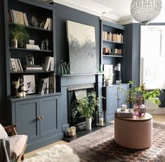 a living room filled with furniture and a fire place in front of a book shelf