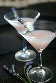 two martinis with lavender garnish sit on a table