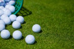 several white golf balls on the green grass