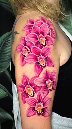 a woman's arm with pink flowers painted on the back of her shoulder and chest