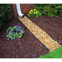 a garden path made out of rocks and mulchs next to a flower bed