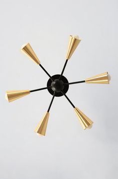 a black and gold chandelier with six lights on each side, hanging from the ceiling