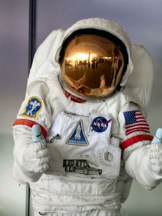 an astronaut is holding something in his hand