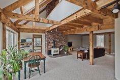 a living room filled with furniture and a fire place next to a brick fireplace covered in wood