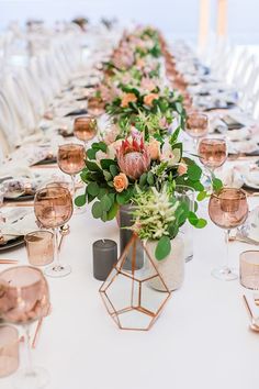 a long table is set with pink and white flowers