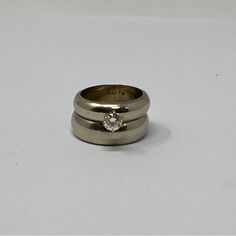 two wedding rings sitting on top of each other with a diamond in the middle,