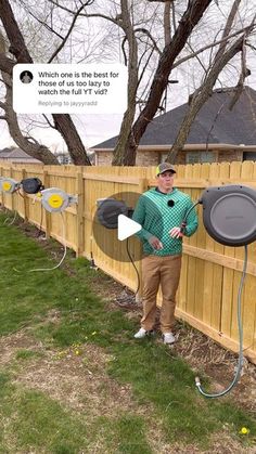 a man standing next to a wooden fence holding an inflatable frisbee