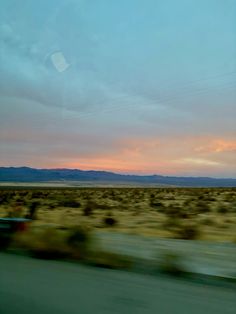 the sun is setting in the distance as seen from a moving car