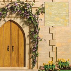 a wooden door with vines and flowers on the side of a brick wall next to green grass