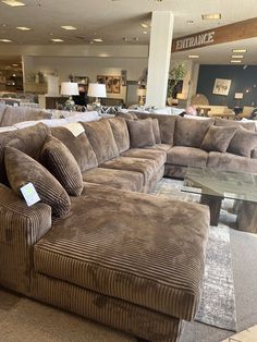 a living room filled with lots of couches and tables in front of a store