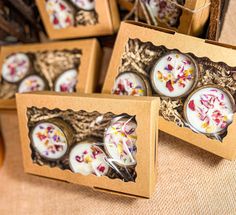 four small boxes with candles in them sitting on a table