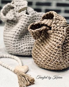 two crocheted purses sitting on top of a table next to each other