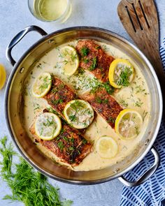 a pan filled with fish covered in sauce and lemons