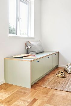 an empty room with a window and some shoes on the floor in front of it