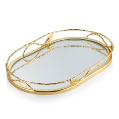 a gold tray with branches on it and a mirror in the middle that is shaped like a leaf