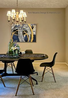 a dining room table with four chairs and a chandelier hanging from the ceiling