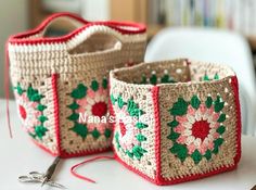 two crocheted baskets sitting on top of a white table next to a pair of scissors