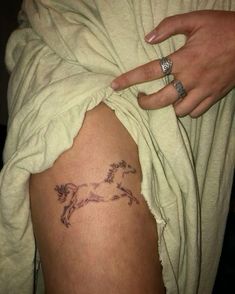 a woman's arm with a horse tattoo on it