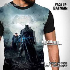 a man wearing a batman t - shirt with the image of two men standing next to each other